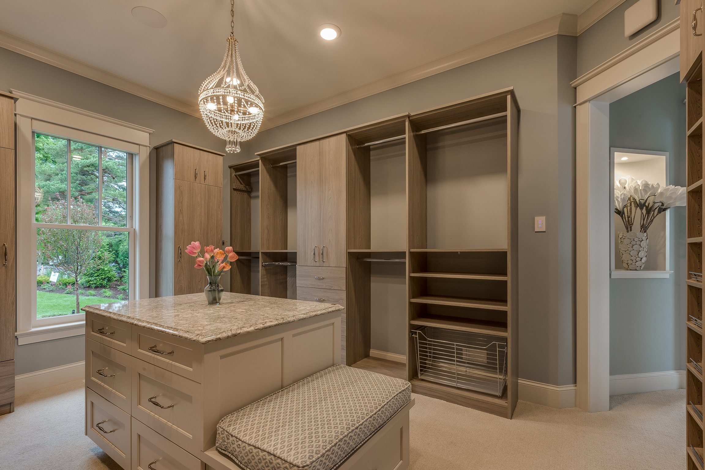 Walk in closet with bench and island dresser